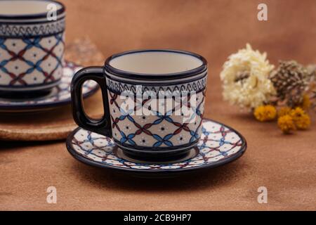 Tassen und Teller Kaffee mit einem traditionellen Design mit Brauner Hintergrund Stockfoto