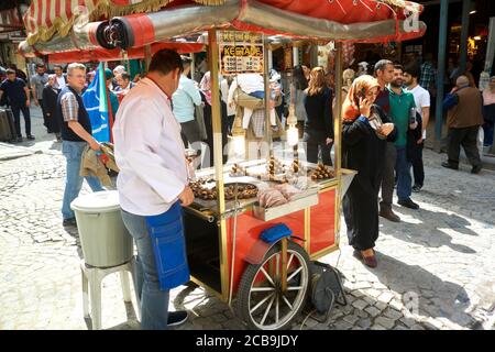 Straßenverkäufer, der im Stadtteil Sultanahmet gebratene Kastanien (ein beliebter Snack entlang Istanbuls geschäftigen Fußgänger) verkauft. Istanbul, Türkei. Stockfoto