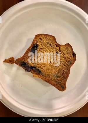 Nehmen Sie glutenfreie und zuckerfreie Tortenscheibe mit Mohn Samen und Heidelbeeren in Plastikteller. Nehmen Sie Gesunde Bio-Dessert. Bereit zum Essen. Stockfoto