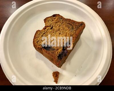 Nehmen Sie glutenfreie und zuckerfreie Tortenscheibe mit Mohn Samen und Heidelbeeren in Plastikteller. Nehmen Sie Gesunde Bio-Dessert. Bereit zum Essen. Stockfoto
