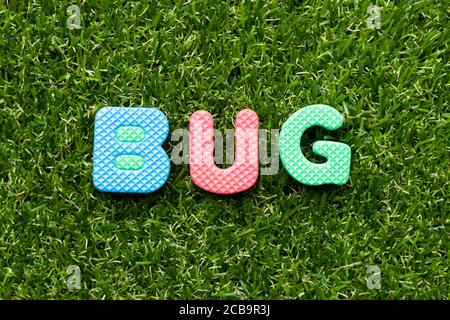 Spielzeug Schaum Buchstaben in Wort Bug auf grünem Gras Hintergrund Stockfoto