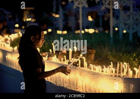 Larantuka, Indonesien. April 2015. Ein Kind zündet Kerzen auf dem Friedhof der Larantuka Kathedrale während des Karfreitagsgedenkens in Larantuka, Insel Flores, Indonesien. Stockfoto