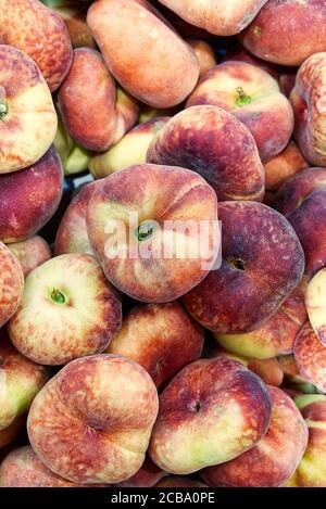 Frische Bio-Flache Pfirsiche Heap Von Frischen Reifen Pfirsichen Auf Dem Markt. Stockfoto