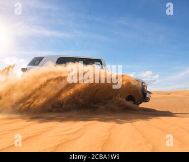 Drifting Offroad Auto 4x4 in der Wüste. Bewegung explodierenden Sandpulvers in die Luft einfrieren. Aktion und Freizeit Aktivität. Stockfoto