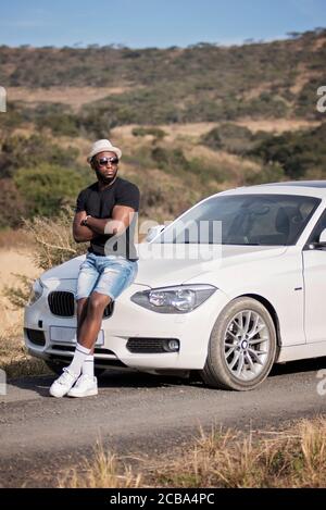 Erfolgreicher afrikanischer oder afroamerikanischer Schwarzmann auf Safari mit Luxuswagen Stockfoto