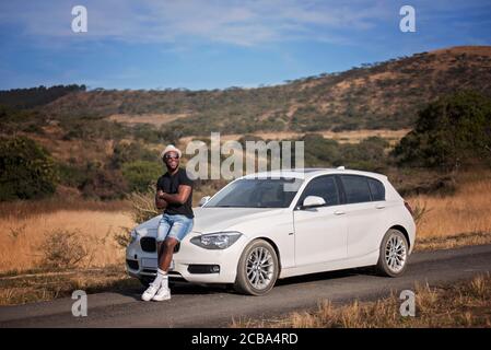 Erfolgreicher afrikanischer oder afroamerikanischer Schwarzmann auf Safari mit Luxuswagen Stockfoto