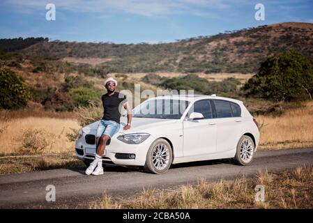 Erfolgreicher afrikanischer oder afroamerikanischer Schwarzmann auf Safari mit Luxuswagen Stockfoto