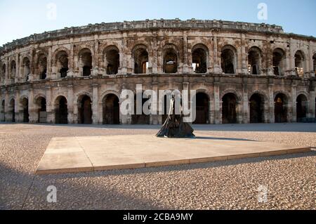 Stierkämpfer-Statue und das elliptische römische Amphitheater in Nimes in Die Region Languedoc-Roussillon in Südfrankreich Stockfoto