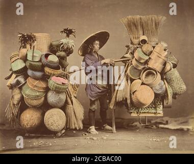 [Japanischer Mann posiert mit Körben, Besen und Federdustern], 1870er Jahre. Stockfoto