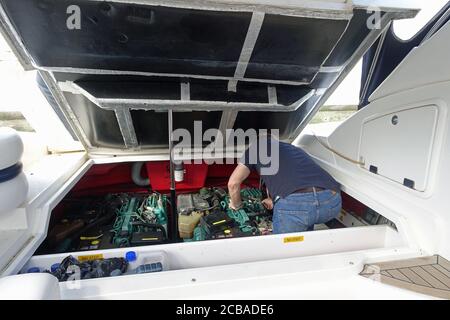Gibraltar, 28. März 2020: Ein Mann, der Wartungsarbeiten macht und versucht, den Motor seines Motorbootes zu reparieren Stockfoto