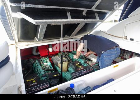 Gibraltar, 28. März 2020: Ein Mann, der Wartungsarbeiten macht und versucht, den Motor seines Motorbootes zu reparieren Stockfoto