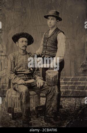 Zwei Maler, einer sitzend und einer stehend, mit Bürsten und einem Eimer, 1860er-80er. Stockfoto