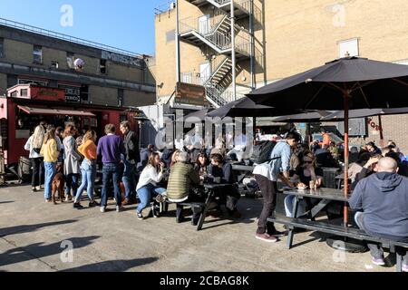 Menschen in Pop-up-Bars und Pop-up-Restaurants in Wilkes Street und Truman Brewery in der Nähe der Brick Lane, Spitalfields, East London, England Stockfoto