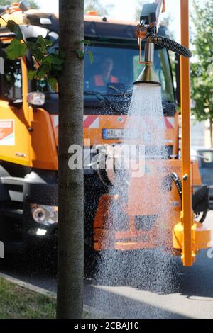 12. August 2020, Sachsen-Anhalt, Halle: Ein Bewässerungsfahrzeug der Wasser- und Stadtwirtschaft bewässert am Straßenrand einen Baum. Seit 10.08.2020 werden Bäume im Stadtgebiet von Halle mit dem neuen Gerät bewässert, das mit einem 12,000-Liter-Tank ausgestattet ist. Foto: Sebastian Willnow/dpa-Zentralbild/ZB Stockfoto