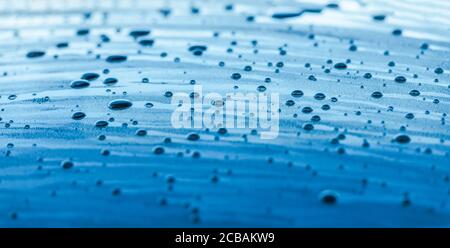 Blaue Karosserie mit Wassertropfen bedeckt Close Up Panoramic Fotohintergrund Stockfoto