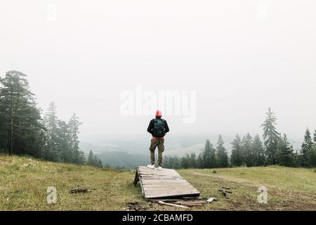 Naturforscher, der den Blick auf eine neblige Bergkette genießt Stockfoto