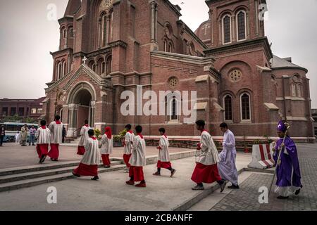 Mess Diner begleiten den Bischof von Lahore, Sebastian Francis Shah zum Sonntagsgottesdienst in der Sacred Heart Cathedral in Lahore in Pakistan. Im Jahr 2015 wurde die Gemeinde in der Kathedrale während eines Bombenanschlags angegriffen, bei dem zahlreiche Opfer gemeldet wurden. Stockfoto