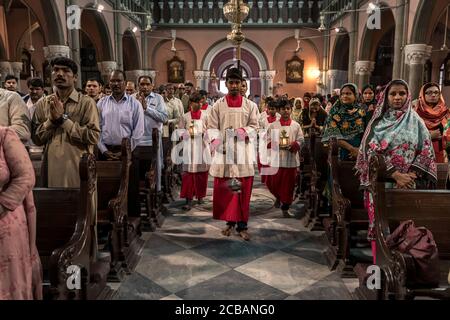 Mess Diner begleiten den Bischof von Lahore, Sebastian Francis Shah zum Sonntagsgottesdienst in der Sacred Heart Cathedral in Lahore in Pakistan. Im Jahr 2015 wurde die Gemeinde in der Kathedrale während eines Bombenanschlags angegriffen, bei dem zahlreiche Opfer gemeldet wurden. Stockfoto