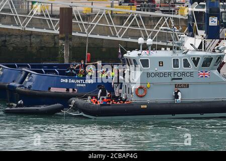 Eine Gruppe von Menschen, die als Migranten gedacht werden, werden von Grenzschutzbeamten nach Dover, Kent, gebracht, nachdem einige kleine Bootsvorfälle im Kanal heute vorgekommen waren. Stockfoto