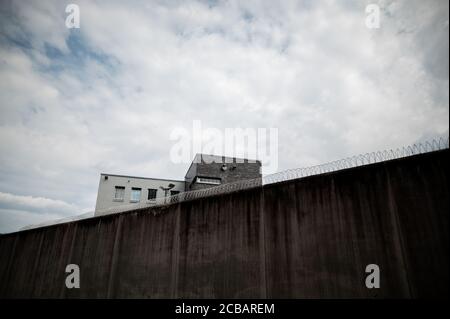 Attendorn, Deutschland. August 2020. Stacheldraht wird an den Wänden des Attendorn Gefängnisses (JVA) angebracht. Nordrhein-Westfalens Justizminister Biesenbach stellt hier das aktuelle telemedizinische Pilotprojekt in Gefängnissen vor. Dank digitaler Technologie können Gefangene rund um die Uhr außerhalb der Bürozeiten und innerhalb der Gefängnismauern mit Live-Übertragungen auf medizinische Versorgung zugreifen. Sieben der 36 Gefängnisse in NRW nehmen an dem Pilotprojekt Teil. Quelle: Fabian Strauch/dpa/Alamy Live News Stockfoto