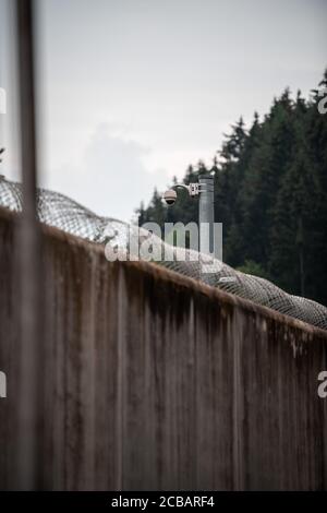 Attendorn, Deutschland. August 2020. Stacheldraht wird an den Wänden des Attendorn Gefängnisses (JVA) angebracht. Nordrhein-Westfalens Justizminister Biesenbach stellt hier das aktuelle telemedizinische Pilotprojekt in Gefängnissen vor. Dank digitaler Technologie können Gefangene rund um die Uhr außerhalb der Bürozeiten und innerhalb der Gefängnismauern mit Live-Übertragungen auf medizinische Versorgung zugreifen. Sieben der 36 Gefängnisse in NRW nehmen an dem Pilotprojekt Teil. Quelle: Fabian Strauch/dpa/Alamy Live News Stockfoto