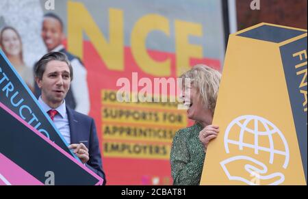 Minister für Weiterbildung und Hochschulbildung Simon Harris und Mary-Liz Trant Executive Director of Skills Development bei SOLAS bei der Ankündigung von 3000 Euro Zuschuss für Arbeitgeber, die auf Auszubildende nehmen mit der Enthüllung einer Plakatwand zur Förderung des Systems in Dublin. Stockfoto