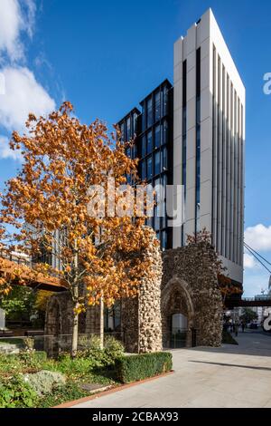 Blick Richtung Osten entlang der Londoner Mauer, mit den Bögen der Ruinen von St. Alphege, roten Herbstblättern und einem der Türme des Schemas. London Wall Stockfoto