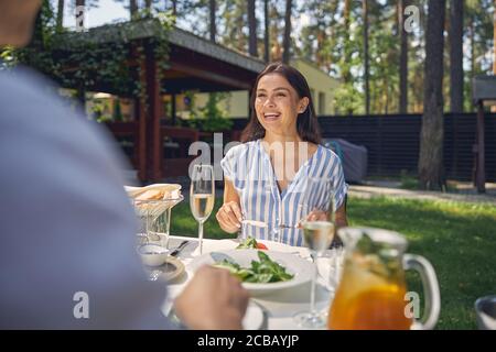 Lächelnde Frau in blauer Bluse hören ihr Mann Stockfoto