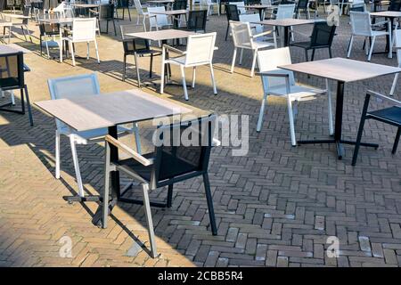 Leere Terrasse eines geschlossenen Restaurants in den Niederlanden mit Platz zwischen Tischen und Stühlen während der Einschränkungen des Coronavirus warten auf Wiedereröffnung. Stockfoto