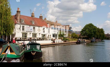 Menschen, die vor dem Cutter Inn am Ufer des Flusses Great Ouse, Cambridgeshire, England sitzen. Stockfoto