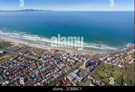 Kapstadt, Westkap / Südafrika - 07/24/2020: Luftaufnahme von Surfern und Wellen am Muizenberg Beach Stockfoto