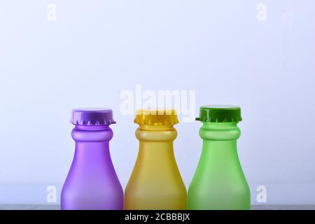 Regenbogen Komposition und Getränkekonzept. Reihe von bunten alkoholfreien Getränken auf hellgrauem Hintergrund. Set von Flaschen in verschiedenen Farben. Energy Drinks Behälter mit verschiedenen Geschmacksrichtungen. Stockfoto