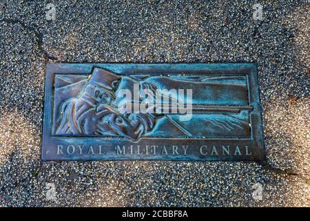 Eine Plakette auf dem Bürgersteig entlang des Royal Military Canal in Hythe, Kent, England Stockfoto