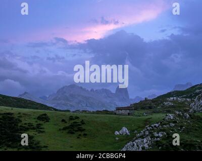 Panoramablick auf den Sonnenuntergang der Picos de Europa von der Mayada de Tordín: Die senkrechte Wand des berühmten Naranjo de Bulnes sticht hervor. Stockfoto