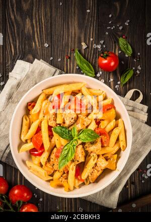 Pasta mit Huhn und Gemüse an Holztisch. Stockfoto