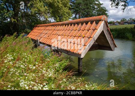 Altes hölzernes Bootshaus, Ziegeldach, Fischteich auf dem Gelände, Doddington Hall Estate, Lincolnshire, England. Schuppen, Lager, Deckel, Dachschutz. Stockfoto