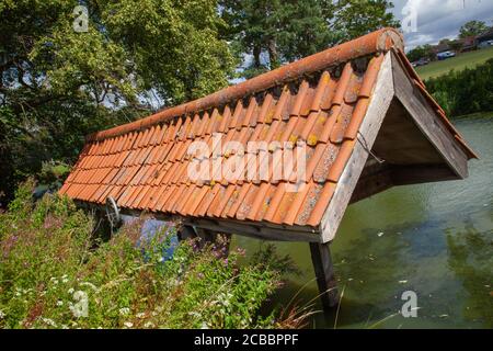 Altes hölzernes Bootshaus, Ziegeldach, Fischteich auf dem Gelände, Doddington Hall Estate, Lincolnshire, England. Schuppen, Lager, Deckel, Dachschutz. Stockfoto