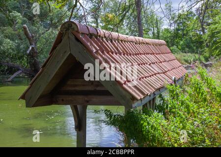 Altes hölzernes Bootshaus, Ziegeldach, Fischteich auf dem Gelände, Doddington Hall Estate, Lincolnshire, England. Schuppen, Lager, Deckel, Dachschutz. Stockfoto