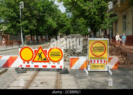 Lviv, Ukraine - 27. Juli 2020 : Schewtschenka Straße im Umbau. Die Innenstadtstraße ist durch Steinsperren gesperrt. Gelbe Straßenschilder mit den Worten Stockfoto