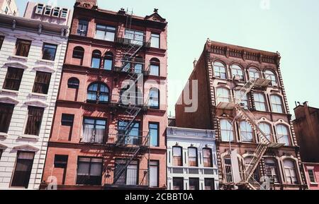 Alte Mietshäuser mit Feuerfluchten, Farbtonierung angewendet, New York City, USA. Stockfoto