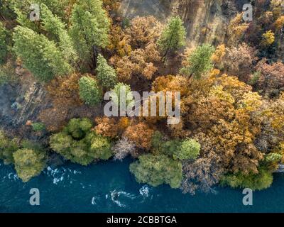 Flussseite - farbenfrohe Herbstbäume Genießen Sie einen kühlen Drink am Pit River. Fall River Mills, Kalifornien, USA Stockfoto