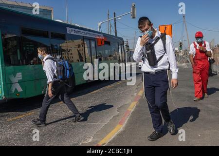 Jerusalem, Israel - 6. August 2020: Junge jüdische orthodoxe Männer mit COVID Masken in Jerusalem. Stockfoto