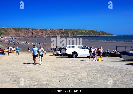 Filey, Yorkshire, Großbritannien. 07. August 2020. Urlauber genießen Freiheit und Sonnenschein nach der Covid-19 Sperre mit der Brigg im Hintergrund Stockfoto