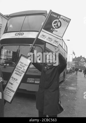 1987, historisch, ein CND-Unterstützer, der ein Busschild hält, das von einem speziell angemieteten Coach vor der Tür steht, damit seine Unterstützer am CND-Treffen im Technical Institue in Eccheshill, Bradford, England, Großbritannien teilnehmen können. Die CND wurde 1958 in Großbritannien gegründet und war eine Protestbewegung gegen den Einsatz und die Produktion von Atomwaffen. Das berühmte Friedenssymbol wurde von Gerald Holtom entworfen. Stockfoto