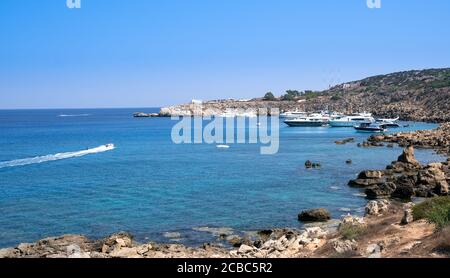 Idyllische Felsküste mit türkisfarbenem Meerwasser und festverankerten Yachten im Sommer. Stockfoto