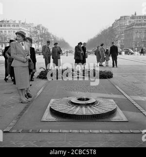 1950er Jahre, historisch, Paris, Frankreich, am Arc de Triomphe, gut gekleidete Menschen an dem Grab geschrieben, "Ici repose UN Soldat Francais Mort Pour La Patrie 1914-1945", das Grab des unbekannten Soldaten des Ersten Weltkriegs mit der ewigen Flamme. Stockfoto