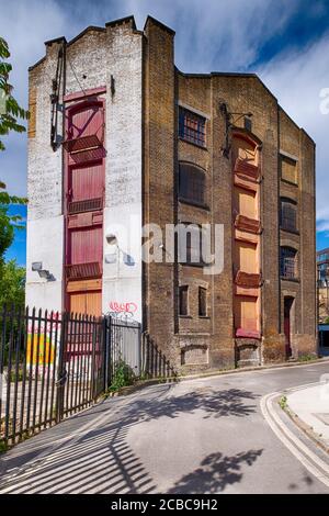 Ein altes Lagerhaus oder eine Fabrik, die für die Renovierung in einer Seitenstraße in Southwark in South London, England, Großbritannien, reif ist Stockfoto