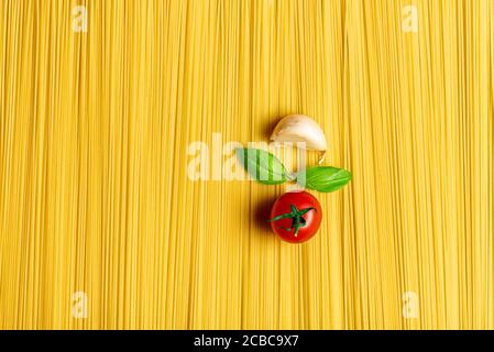 Flach mit rohen Spaghetti und den Zutaten für die traditionelle italienische Tomatensauce legen. Abstrakter Hintergrund mit einem Stapel ungekochte Spaghetti Stockfoto