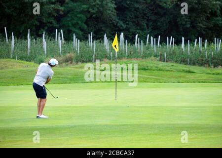 Verschwommene Bewegung eines männlichen Golfers beim Abschlag im Blue Monster Golfclub in Südtirol, Italien im Sommer 2020. Stockfoto