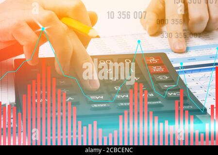 Geschäftsmann setzt auf einen Rechner. Diagramm und Zahlen zum Gewinnwachstum. Umsatzprognose und Datenanalyse des Unternehmens. Geschäftskonzept. Getöntes Foto. Stockfoto